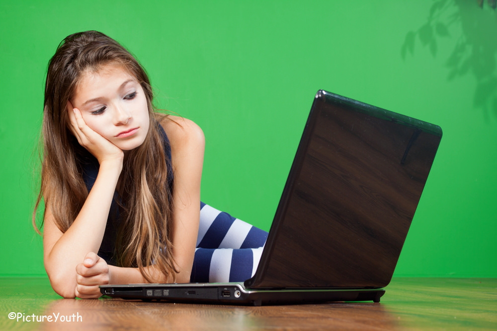 photo of teenage girl using laptop