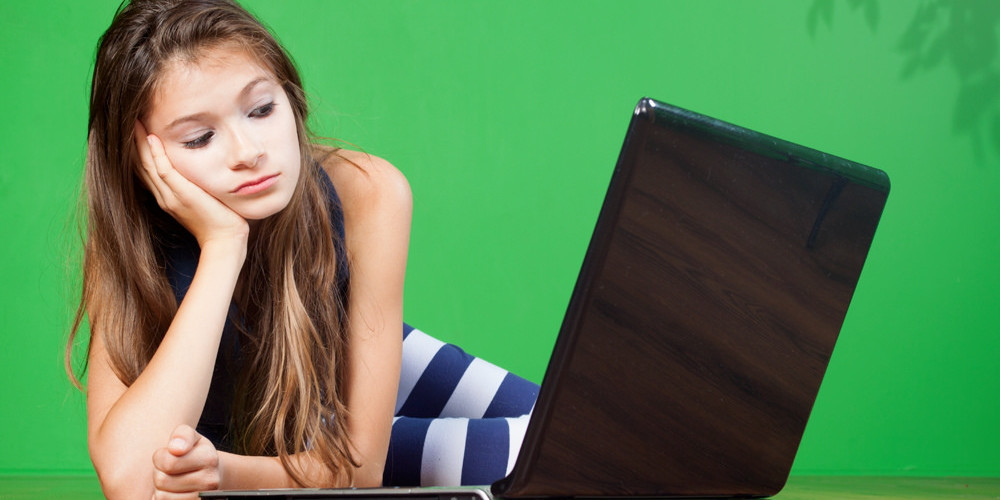 photo of teenage girl using laptop